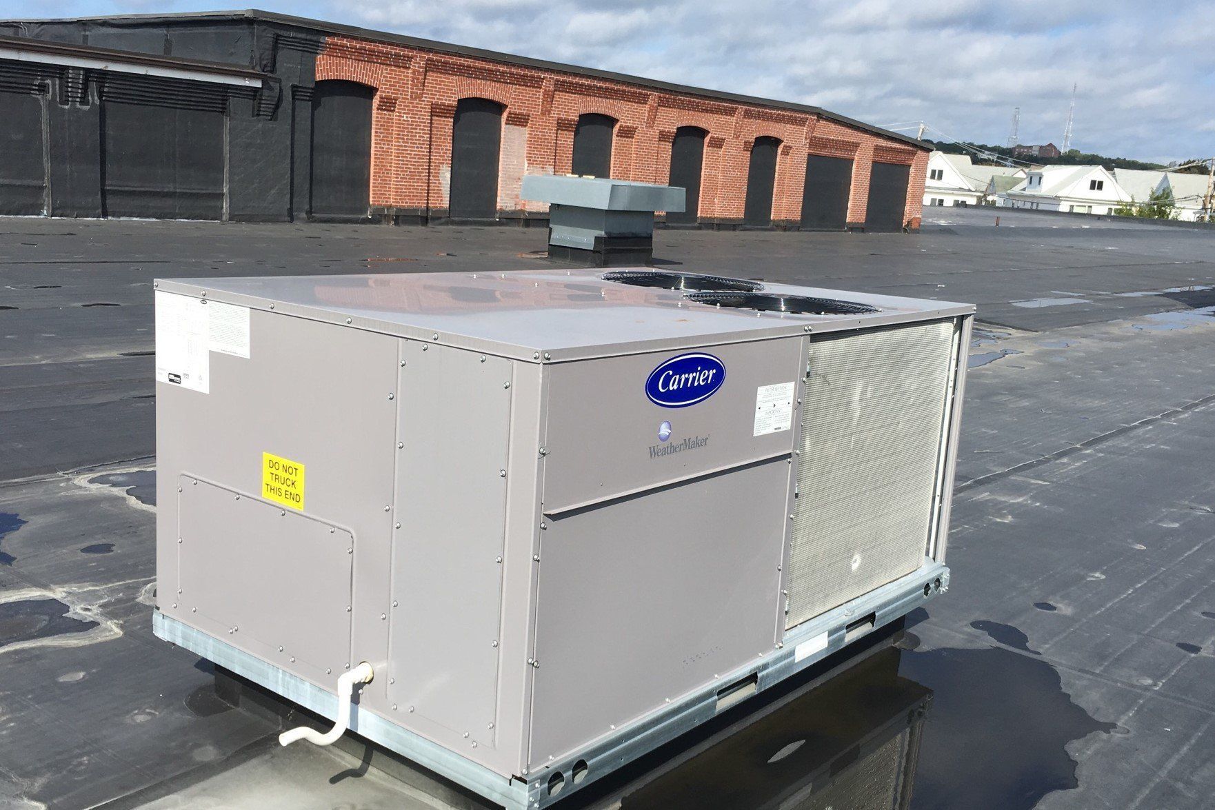 A carrier air conditioner is sitting on the roof of a building
