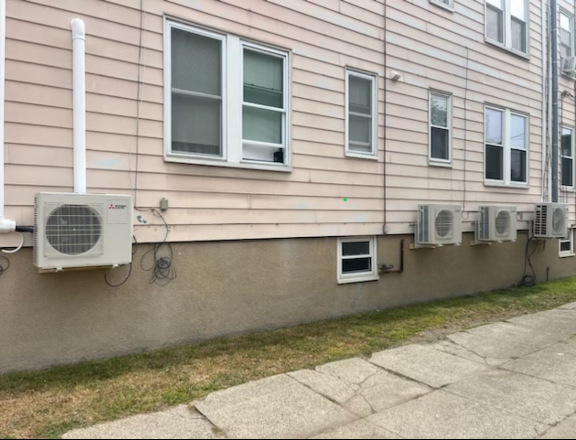 A row of air conditioners on the side of a building