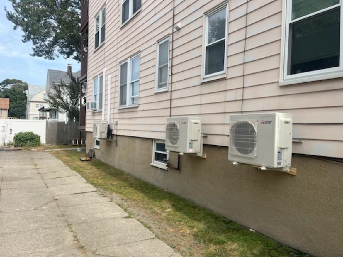There are three air conditioners on the side of a building.