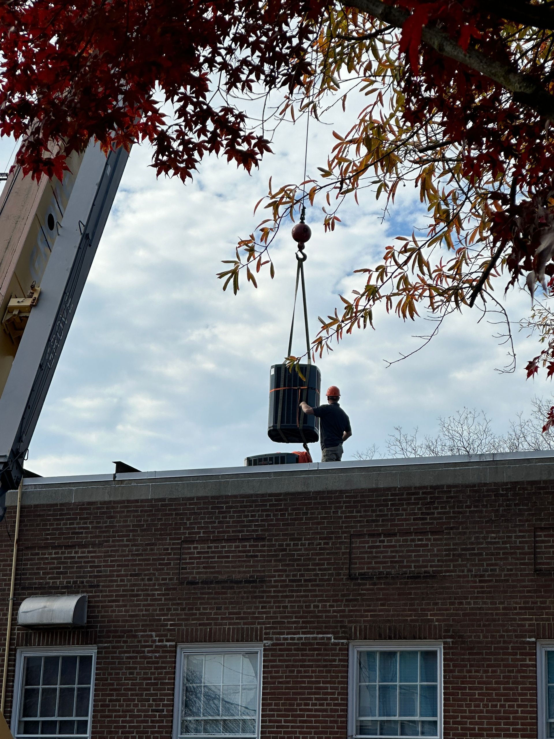 A man is standing on the roof of a brick building