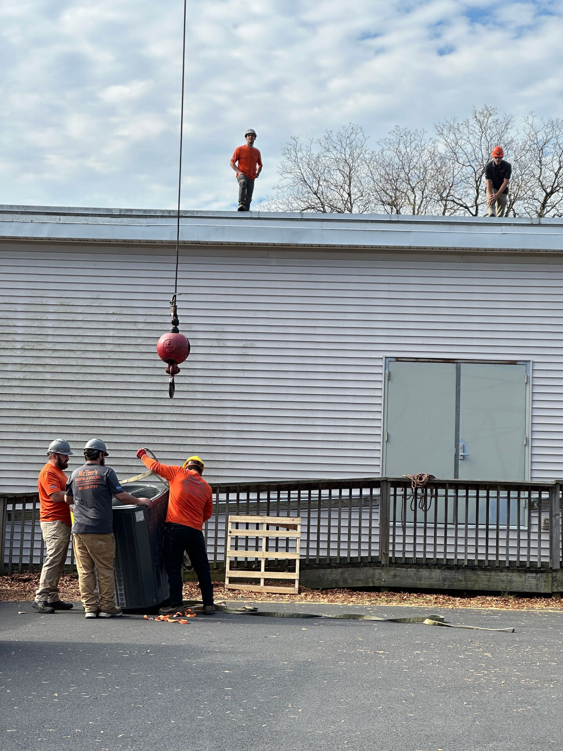 A group of men are working on the roof of a building