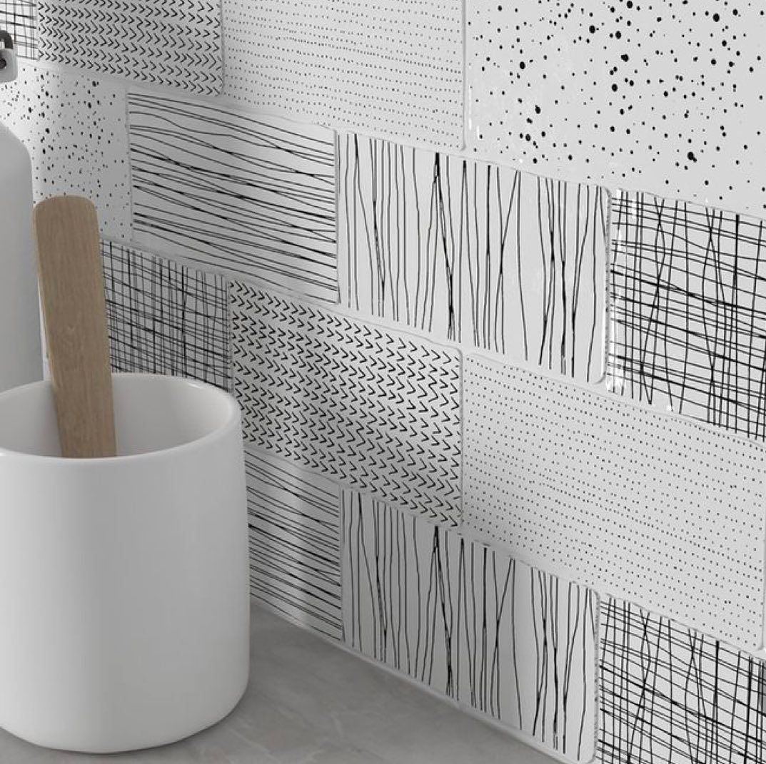 A bathroom with a sink and a toothbrush holder next to a wall.