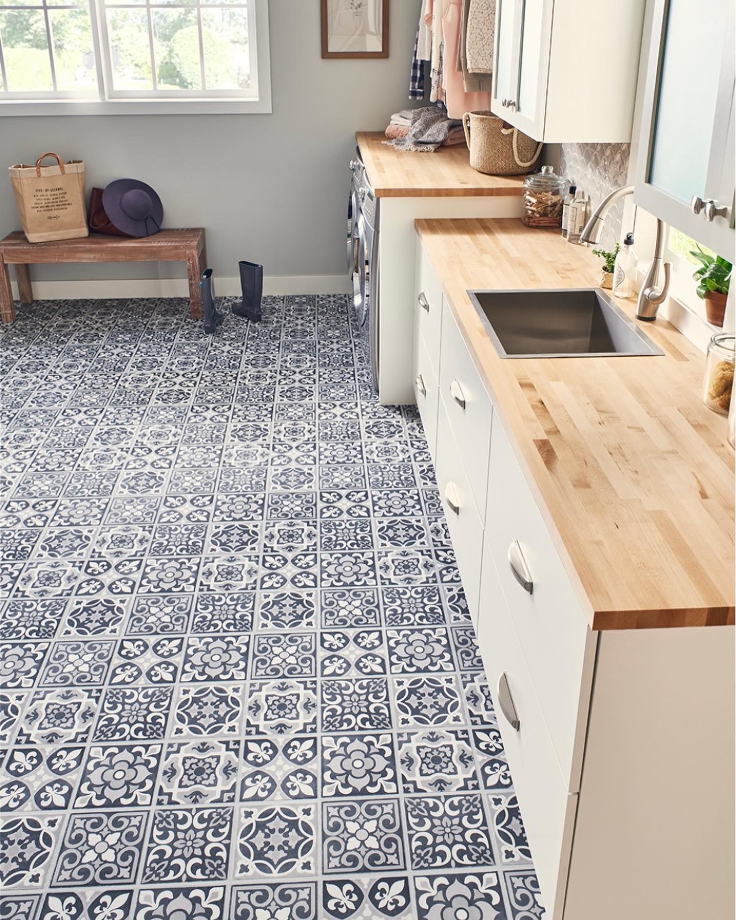 A kitchen with a wooden counter top and tile floor.