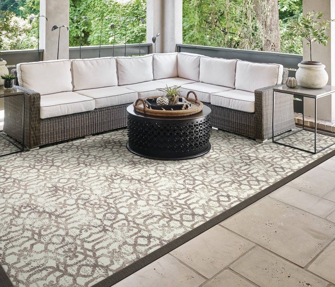 A living room with a sectional couch, coffee table, and rug.