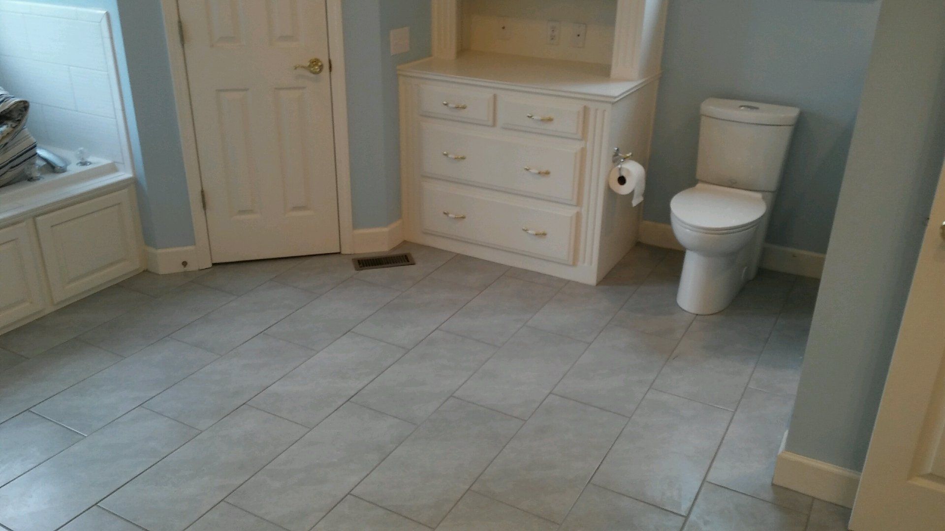 There is a toilet and a dresser in the bathroom.