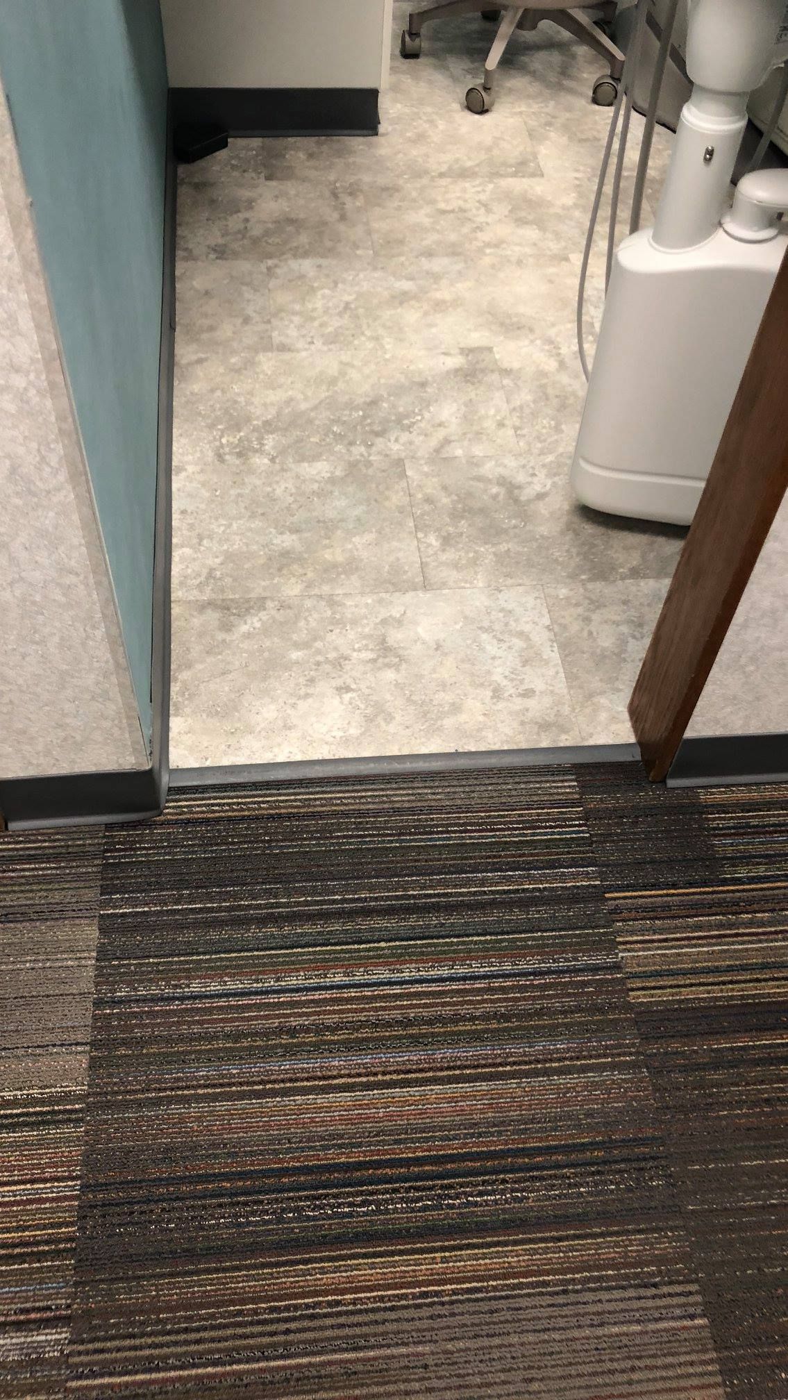 A doorway with a carpeted floor in a dental office.