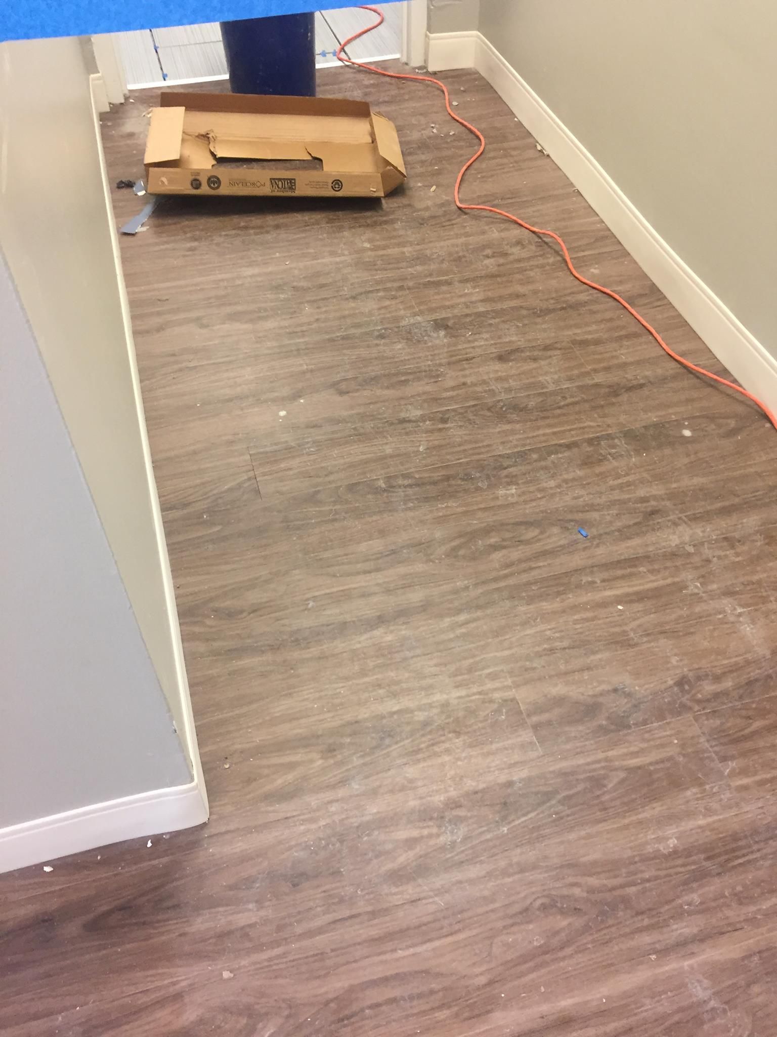 A cardboard box is sitting on a wooden floor in a room.