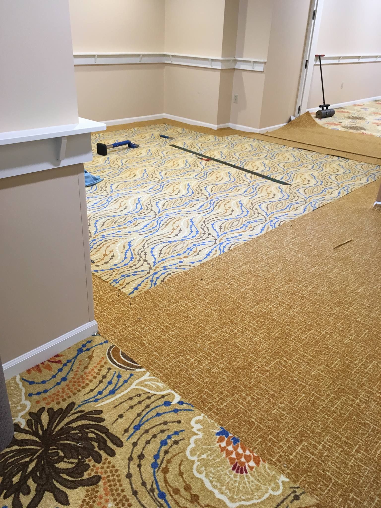 A room with a carpet on the floor and a ladder.