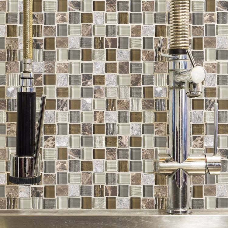 A kitchen sink with a faucet and a tiled wall