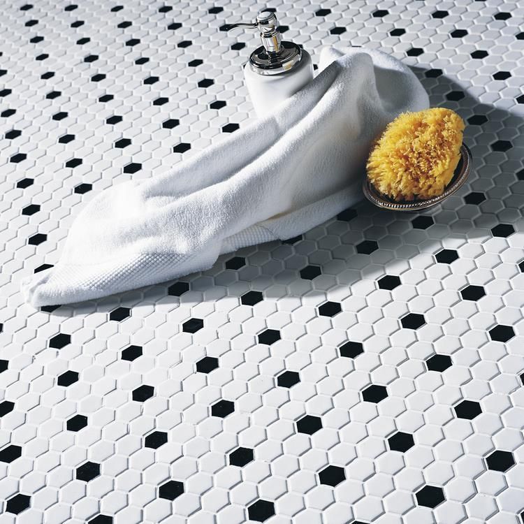 A black and white tile floor with a towel and sponge on it