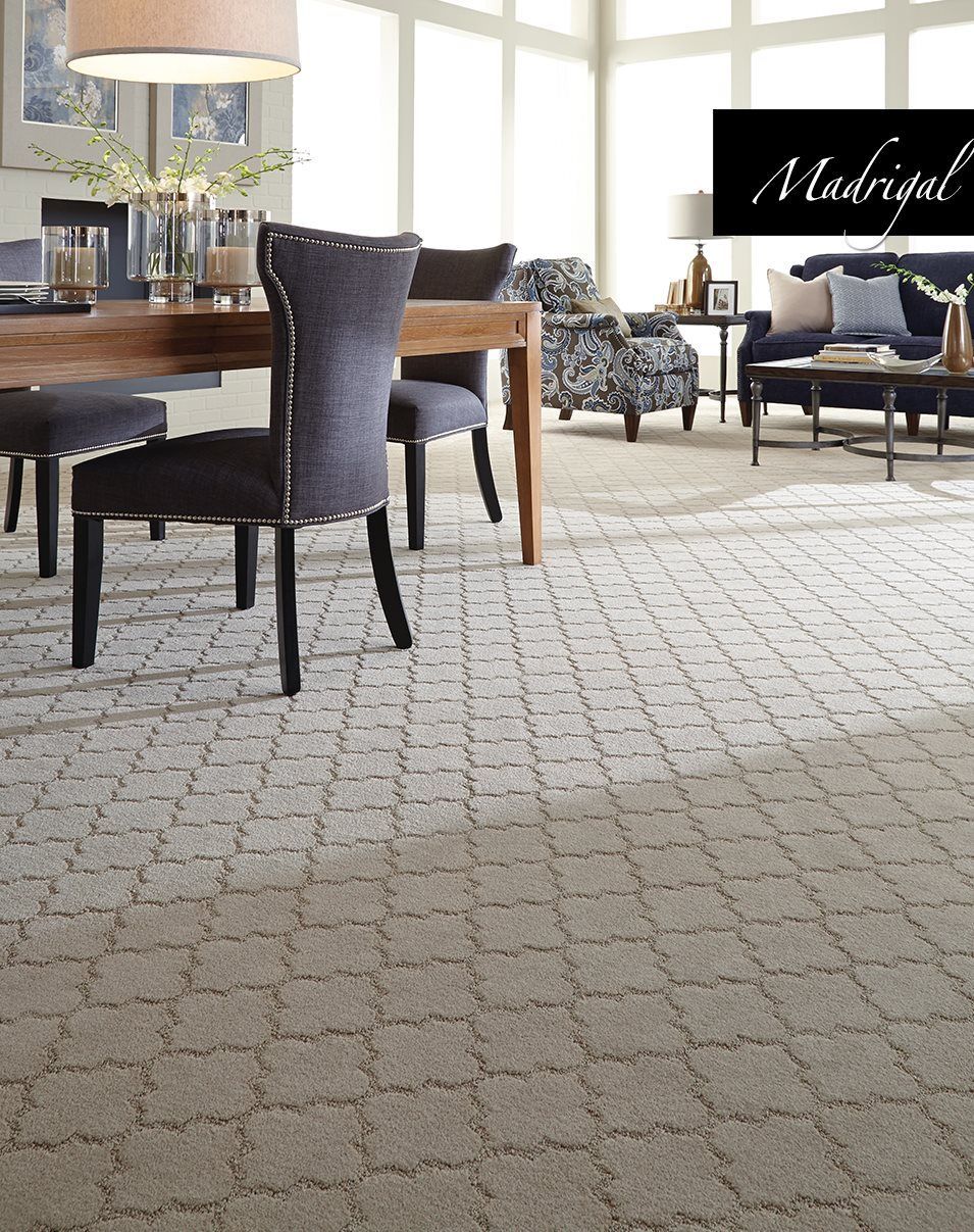 A dining room with a table and chairs and a sign that says madrigal