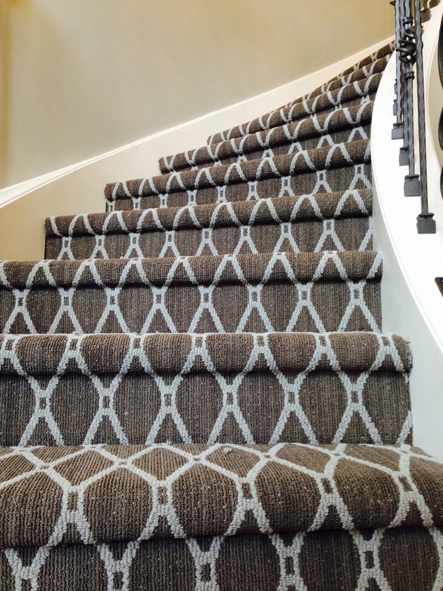A close up of a set of stairs with a pattern on the carpet.