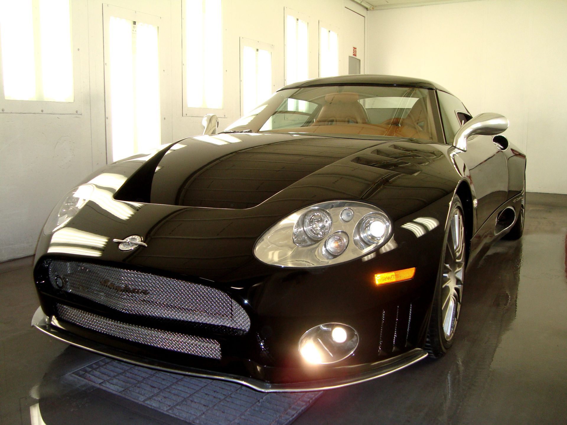 A black sports car is parked in a garage