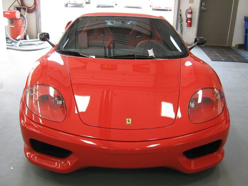 A red ferrari sports car is parked in a garage