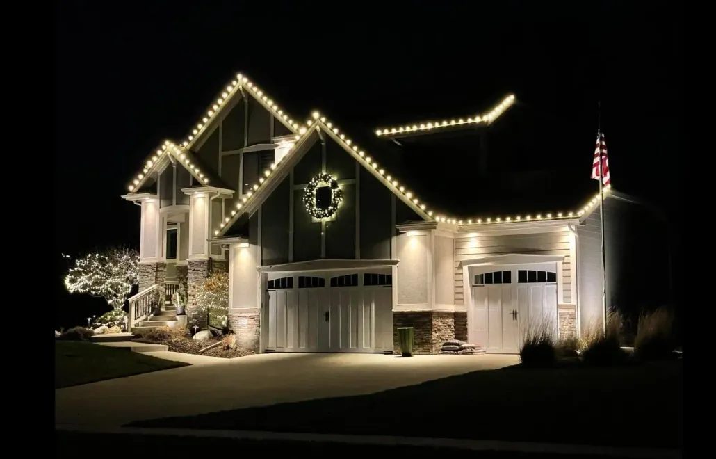 House decorated with warm yellow Christmas lights at night.