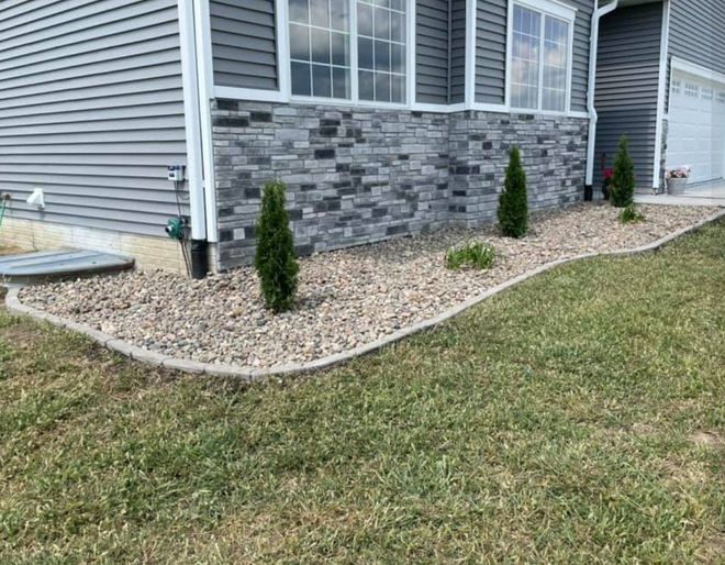 People laying sod in a backyard, using pallets. Green grass, blue jeans, green shirts.