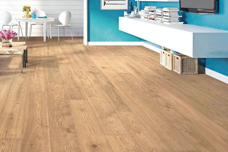 Wooden floor in a room with blue walls and white furniture.