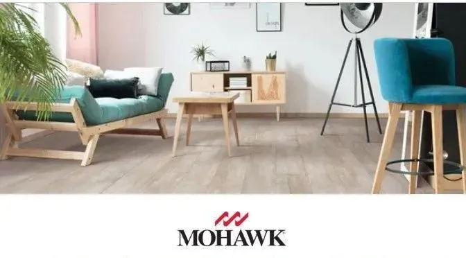 Living room with Mohawk flooring; teal sofa, wooden furniture, and stool.