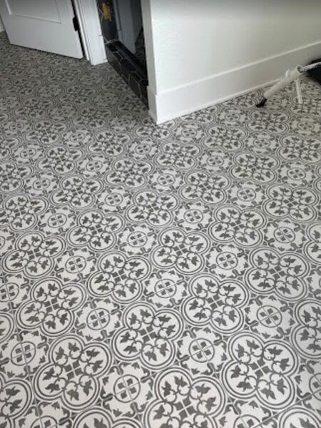 Decorative patterned floor tiles in grey and white.