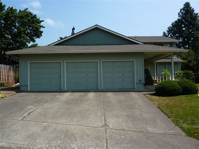 A house with three garage doors and a driveway