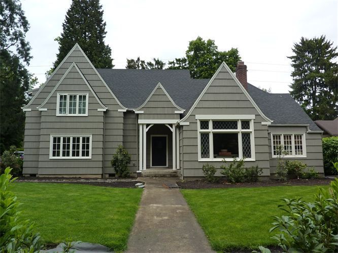A gray house with a black roof and white trim