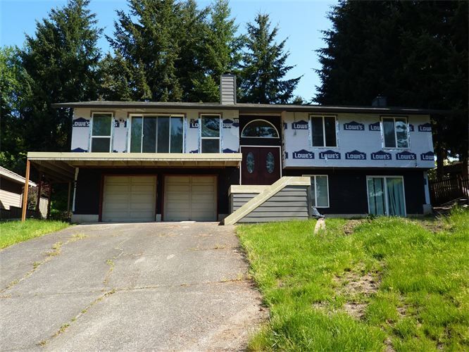A house with a lot of windows and a driveway