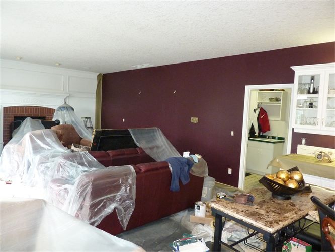 A living room with purple walls and a red couch
