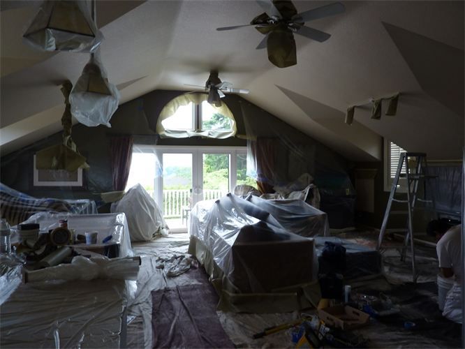 A living room with a lot of furniture and a ceiling fan