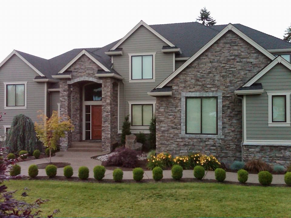 A large house with a lot of windows and bushes in front of it