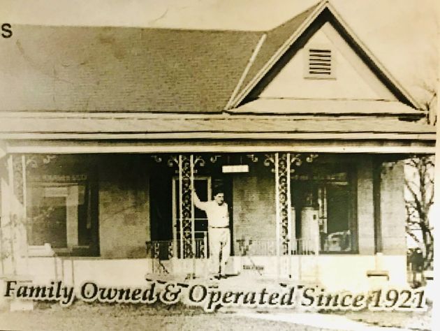 Sepia photo of a house with porch sign reading “Family Owned & Operated Since 1921”
