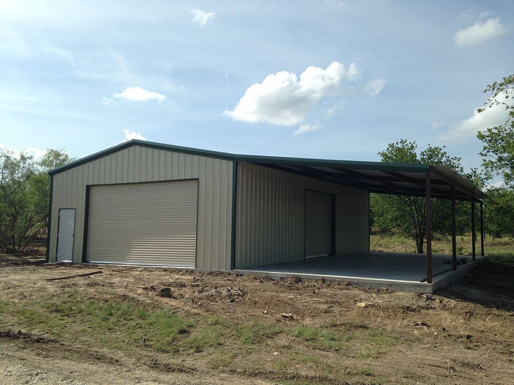 A large metal building with a canopy and a garage door
