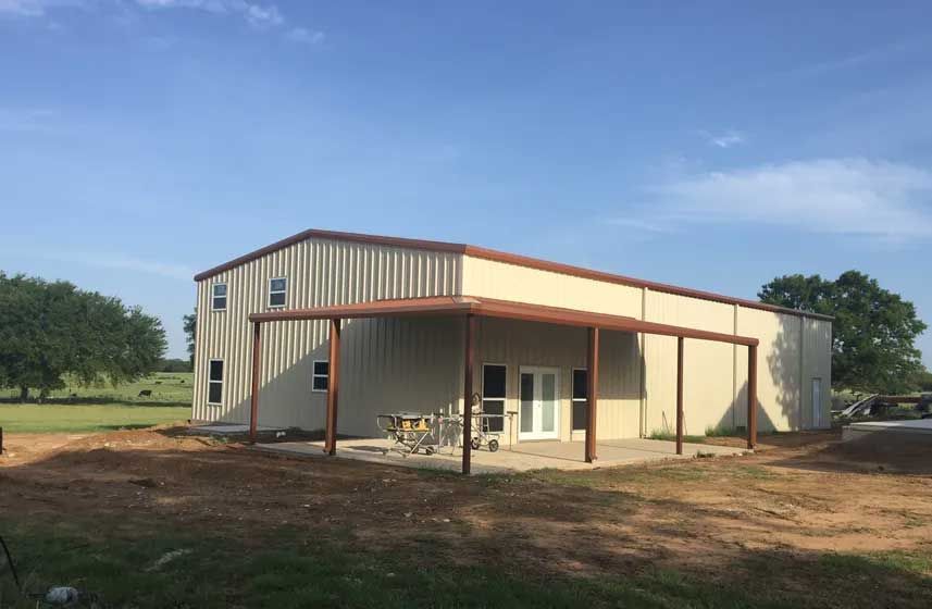 A large metal building with a covered porch in front of it.