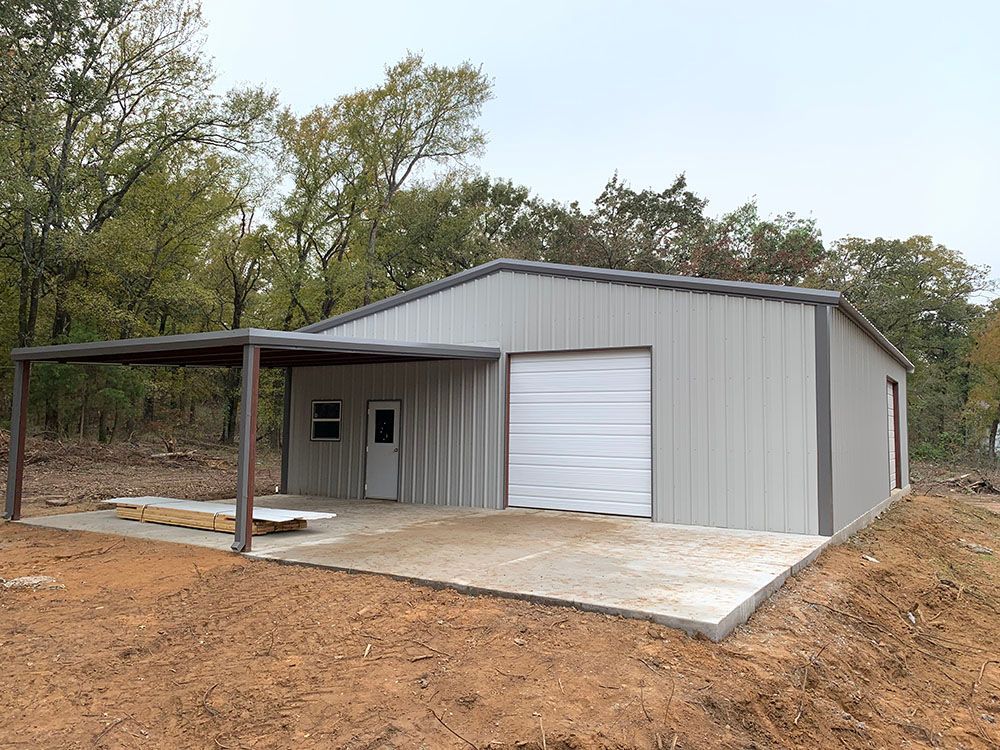 A metal building with a garage door and a canopy.