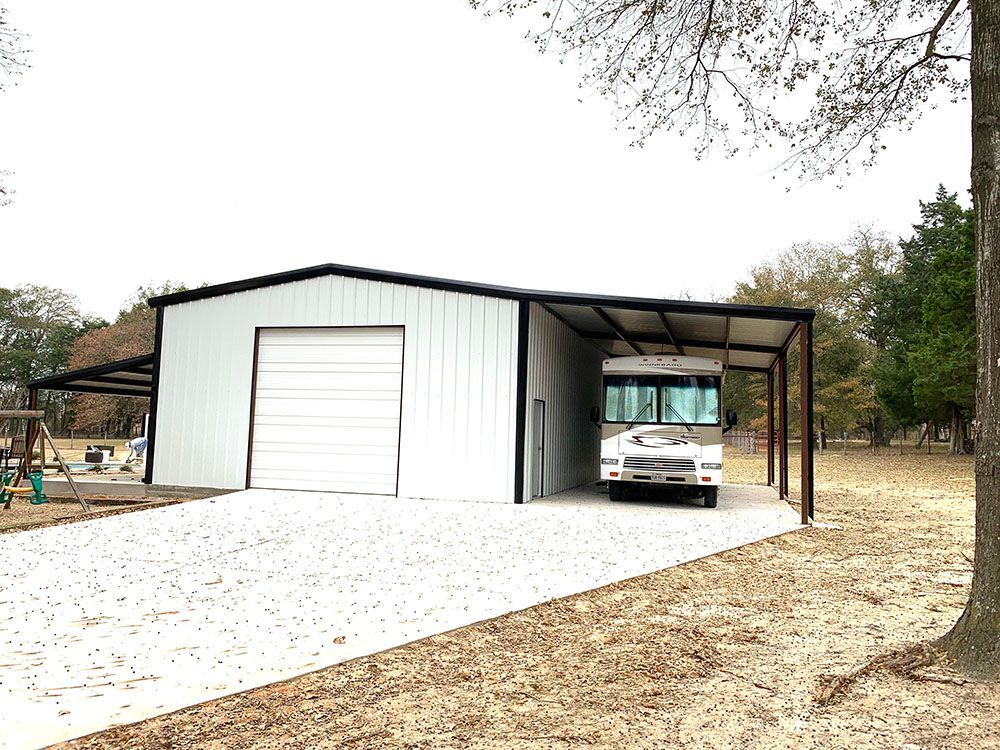 A rv is parked in a garage under a canopy.