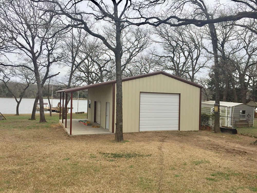 A metal garage with a porch and a white garage door.