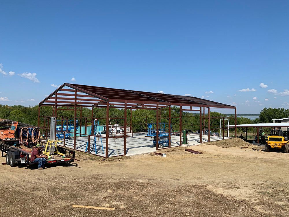 A large metal structure is being built in a field.