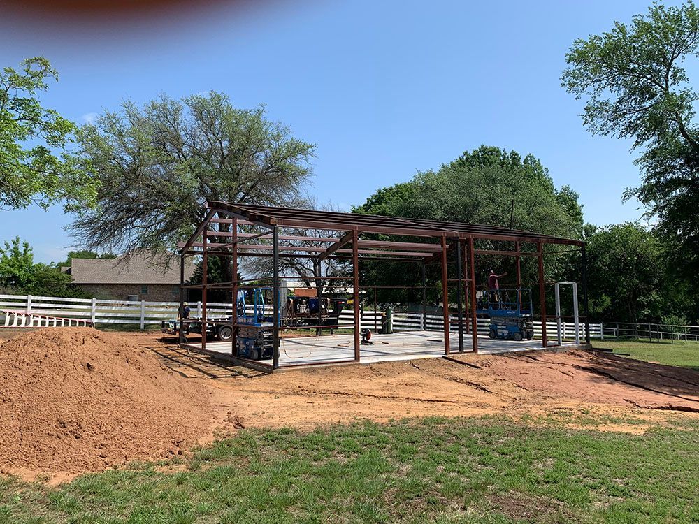 A metal structure is being built in the middle of a grassy field.