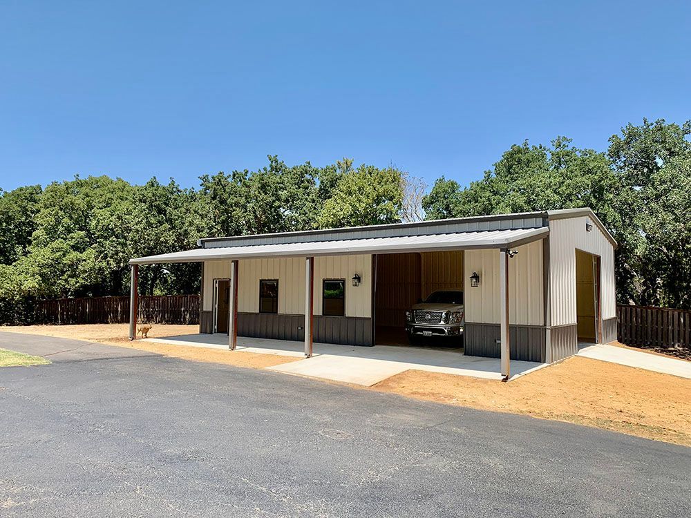 A truck is parked in a garage with a covered porch.