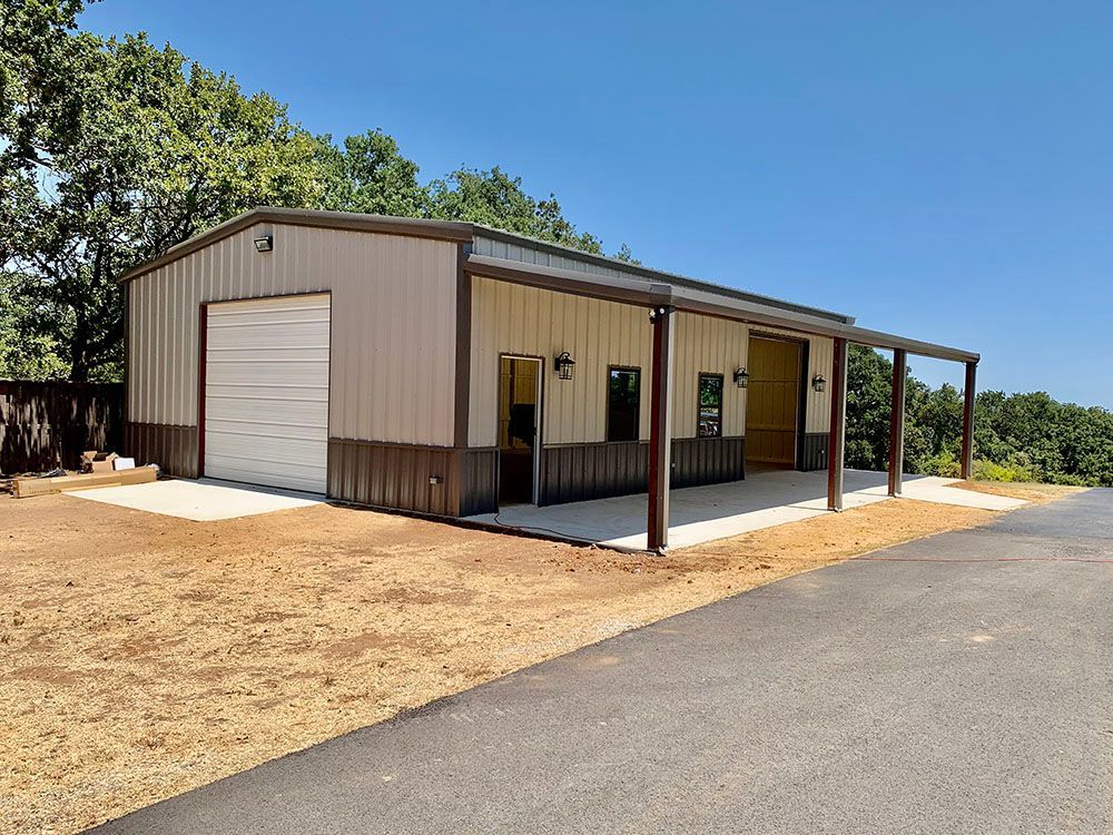 A large metal building with a garage and a porch.