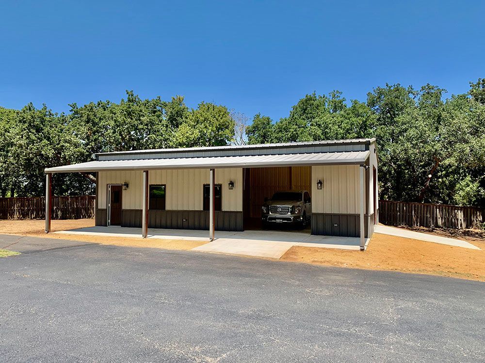 A truck is parked in a garage under a canopy.