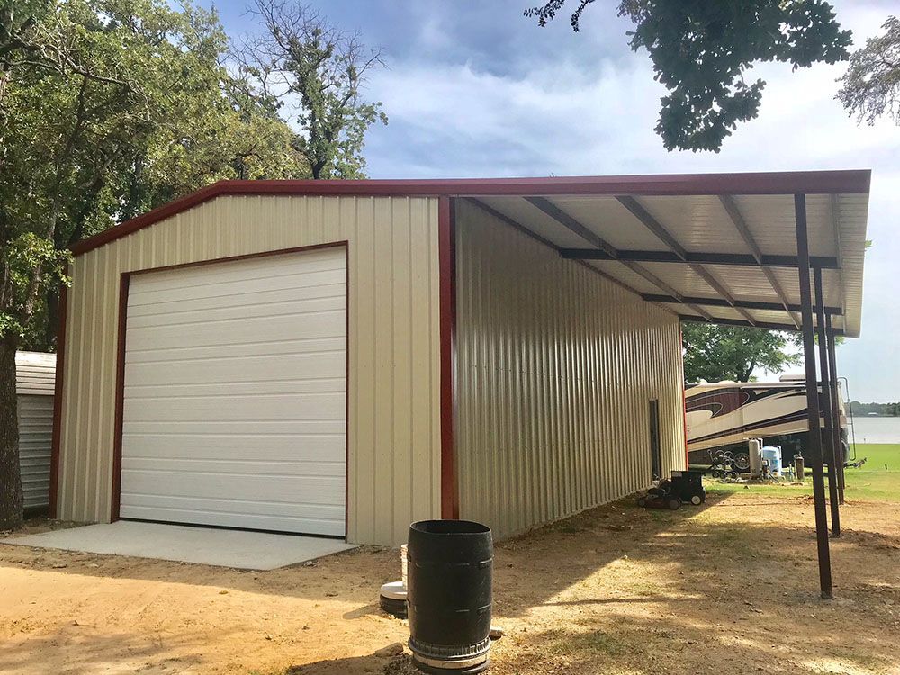 A metal garage with a carport attached to it.