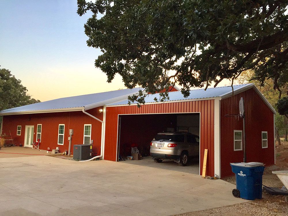 A car is parked in the garage of a red building