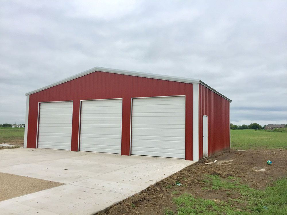 A red and white garage with three white garage doors.