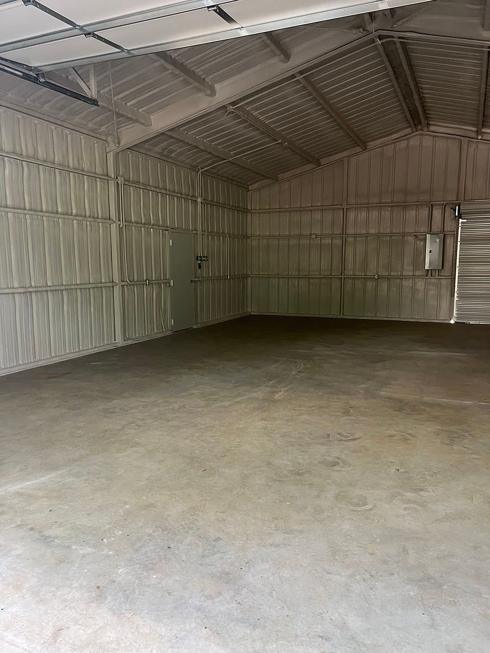 An empty warehouse with a concrete floor and walls covered in foam.