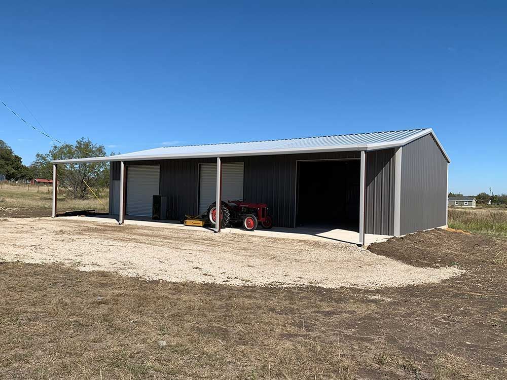 A barn with a tractor parked inside of it.