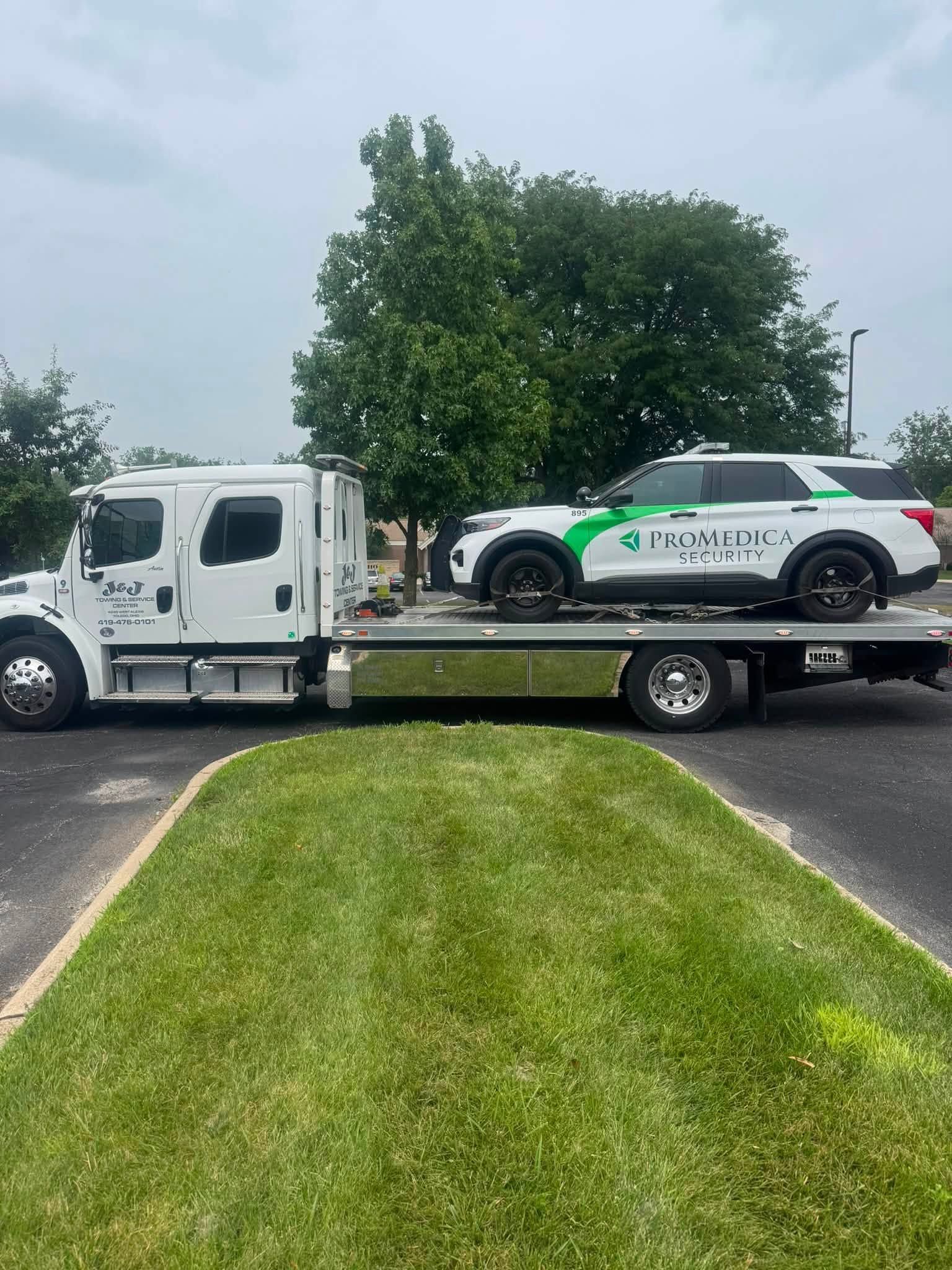 White tow truck hauling an SUV