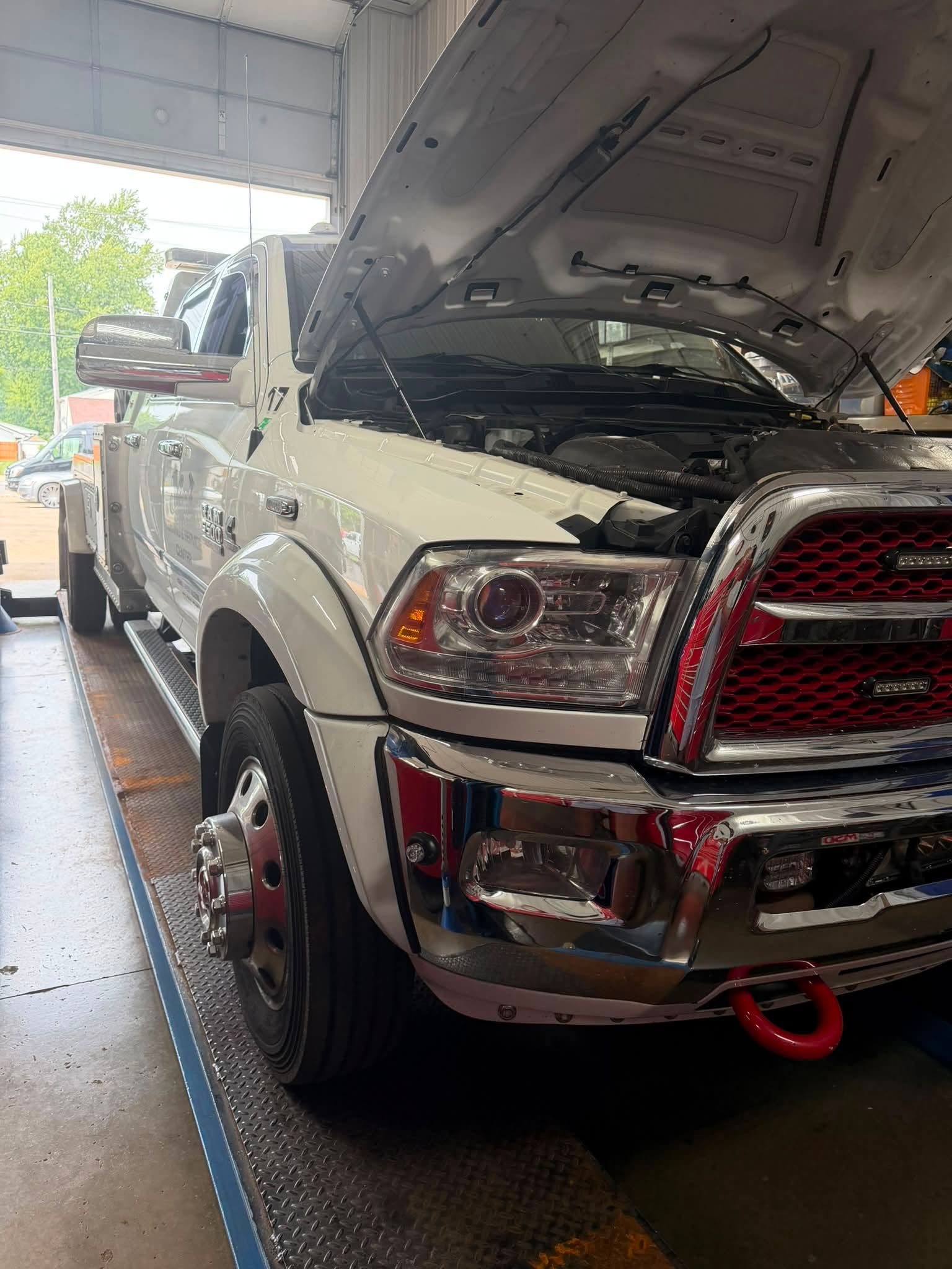 White pickup truck with hood open in a garage