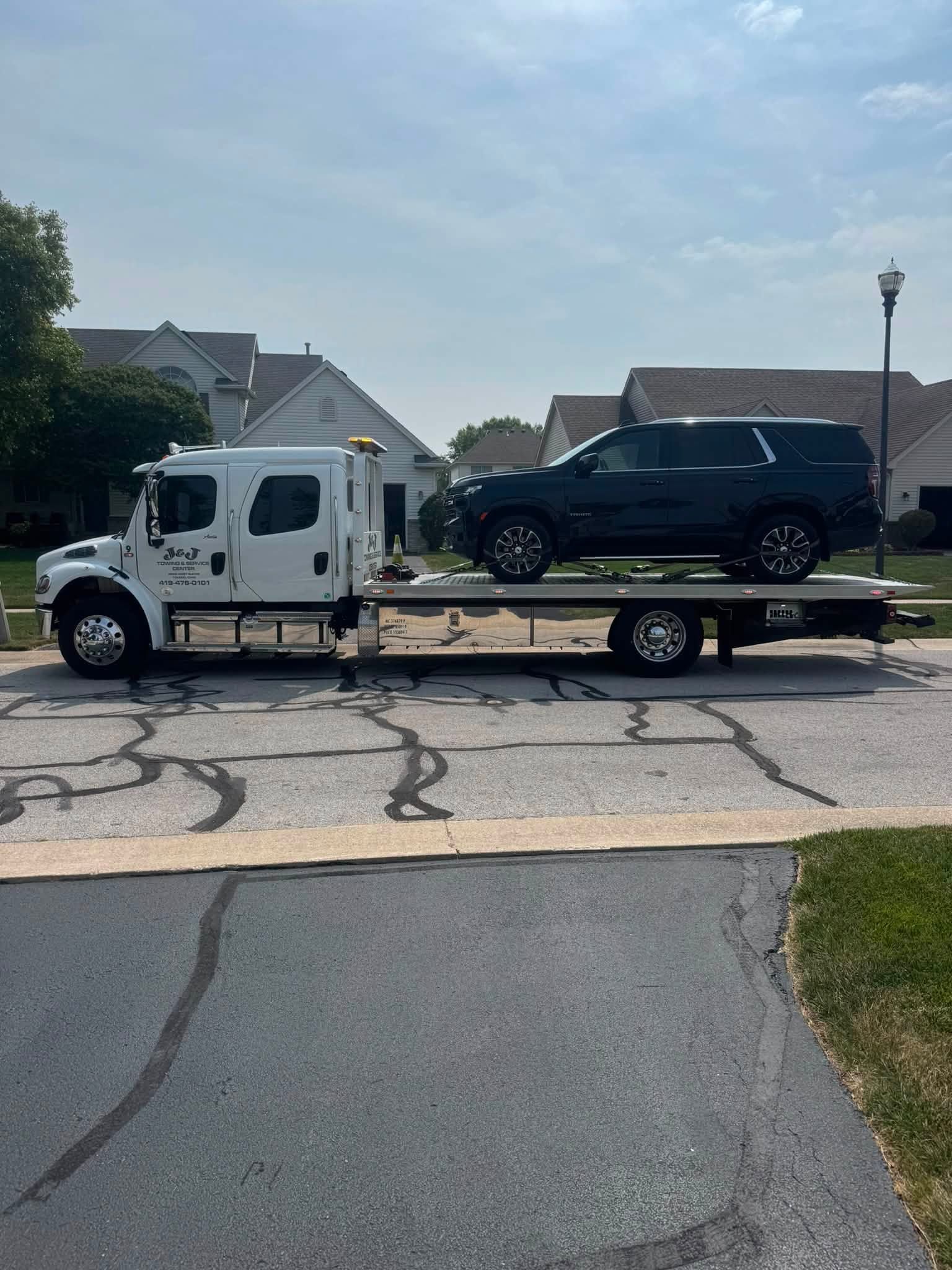Tow truck carrying a black SUV