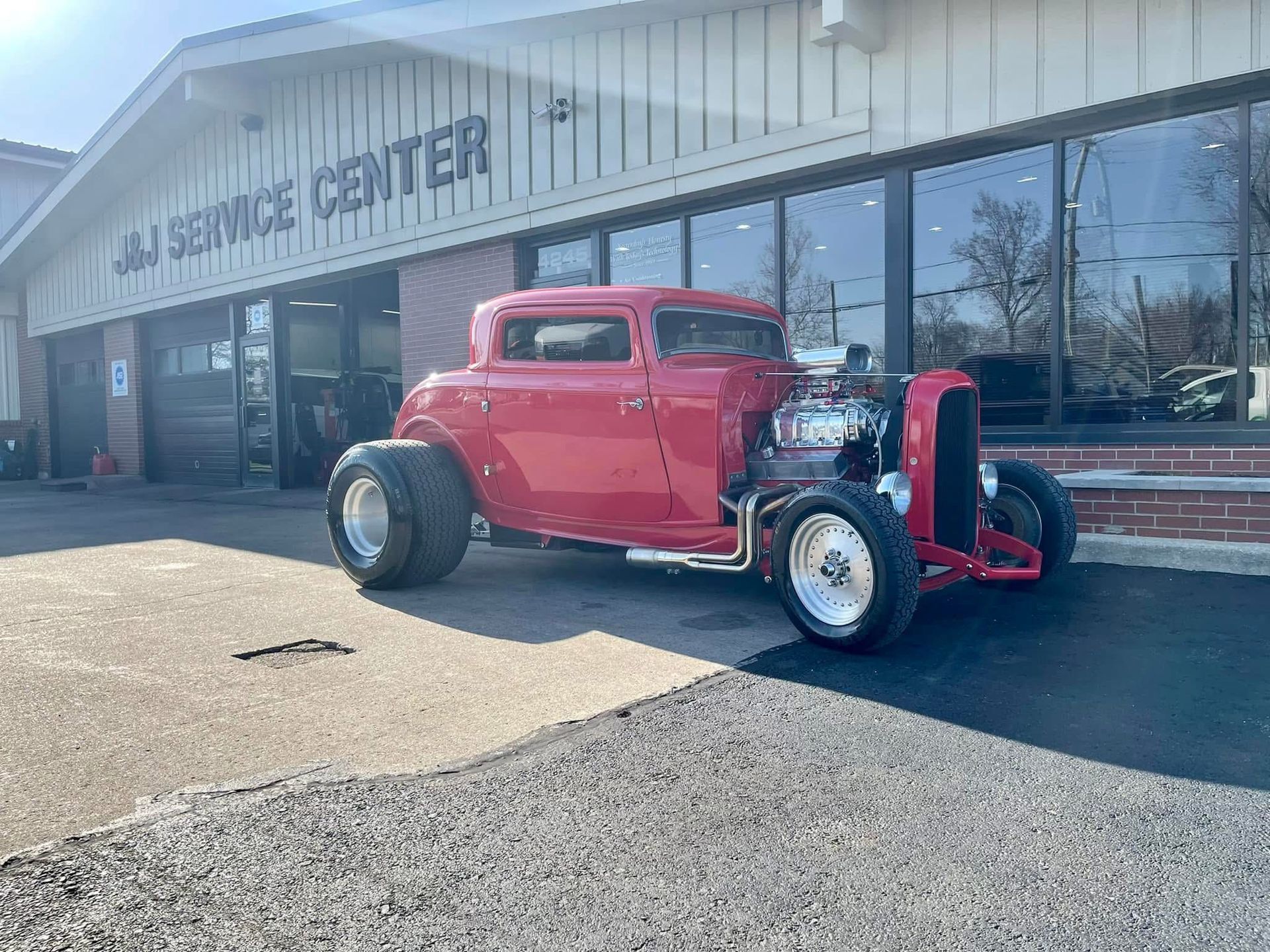 Red hot rod parked in front of J&I Service Center.