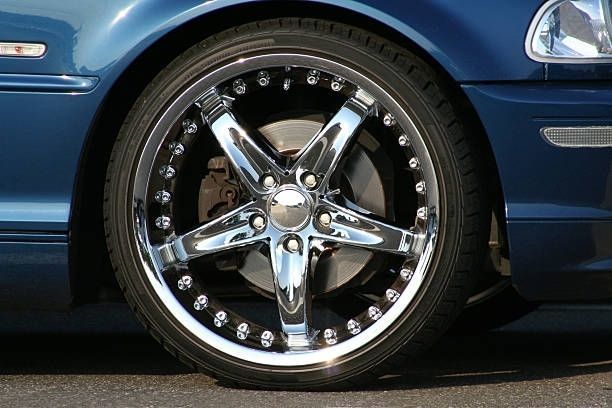 Chrome alloy wheel on a blue car.